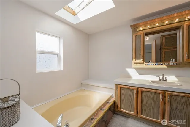 a bathroom with a tub sink and mirror