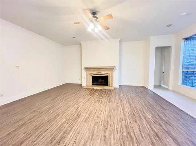 a view of empty room with wooden floor and fireplace