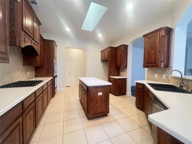 a kitchen with stainless steel appliances granite countertop a stove a sink dishwasher and a refrigerator