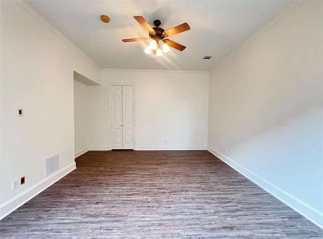 a view of an empty room with window and wooden floor