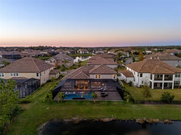 an aerial view of a house with a garden and lake view