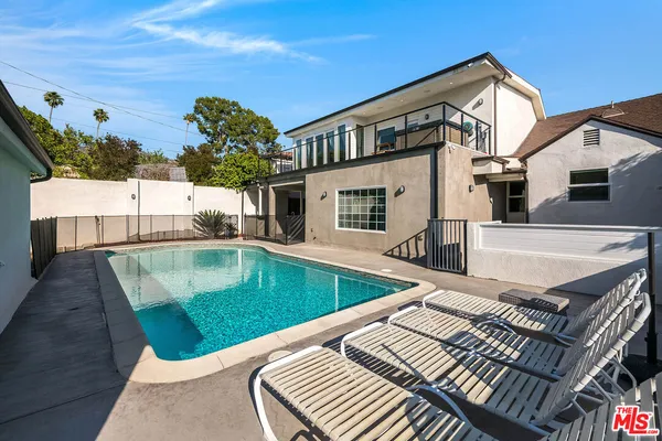 a view of a house with pool and a yard