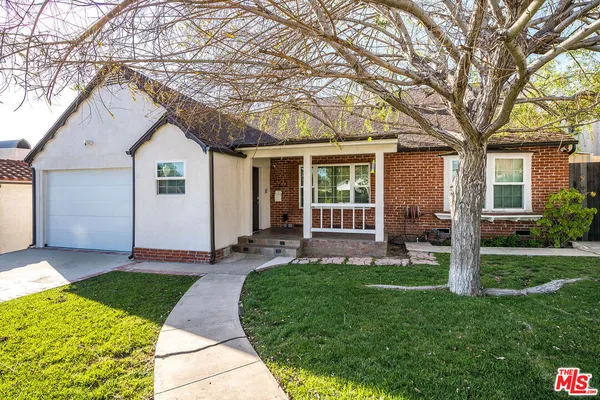 a view of a house with a yard and tree s