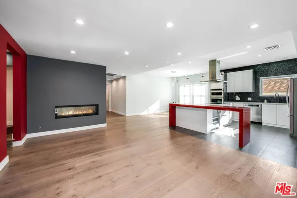 a view of kitchen with kitchen island granite countertop stainless steel appliances refrigerator oven stove and cabinets