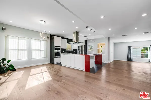 a view of kitchen with kitchen island sink refrigerator and window