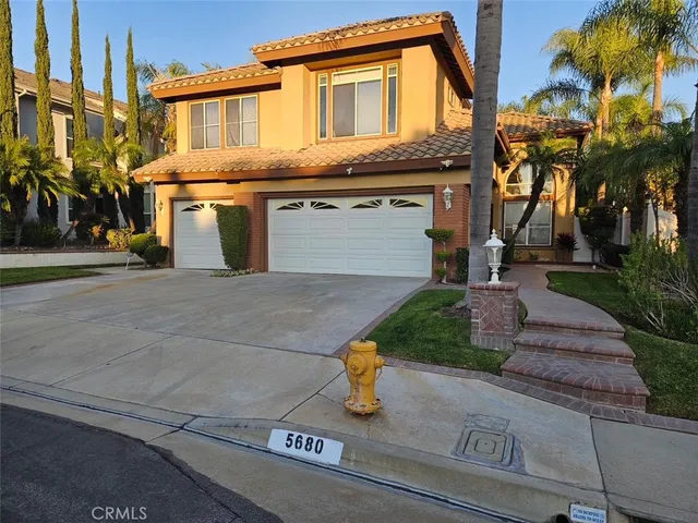 a front view of a house with a yard and fountain
