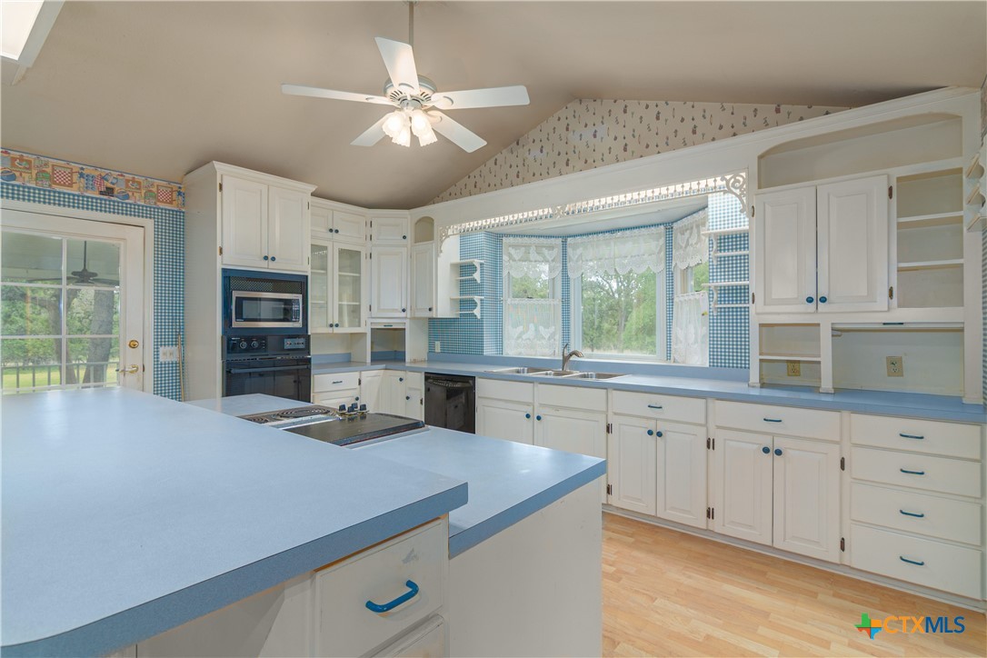 2981 Vivroux Ranch Road Seguin, TX 78155 - Photo 12 of 43 a kitchen with stainless steel appliances granite countertop a sink a stove and cabinets