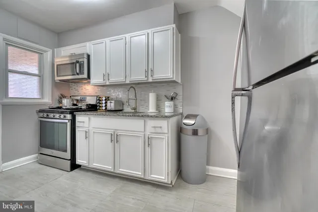 a kitchen with stainless steel appliances granite countertop a refrigerator sink and cabinets