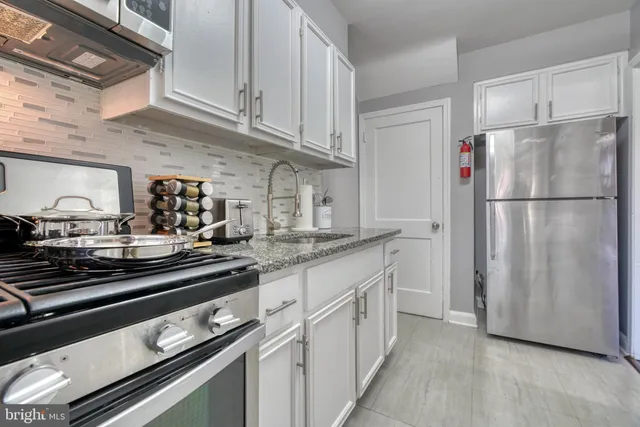 a kitchen with appliances a sink and cabinets