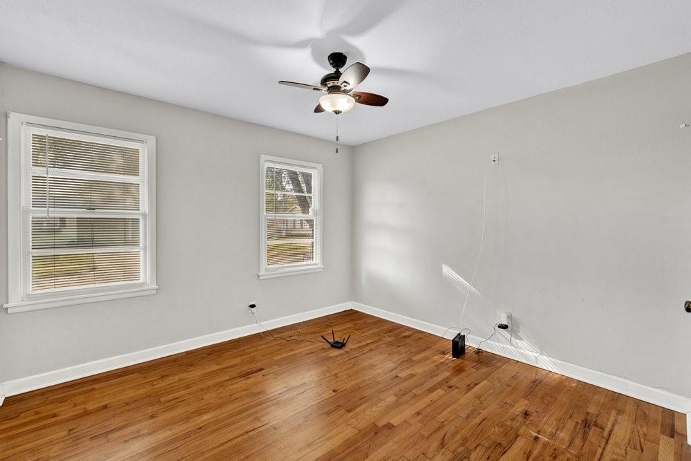 6833 Norma Street Fort Worth, TX 76112 - Photo 11 of 17 a view of a room with window a ceiling fan and wooden floor