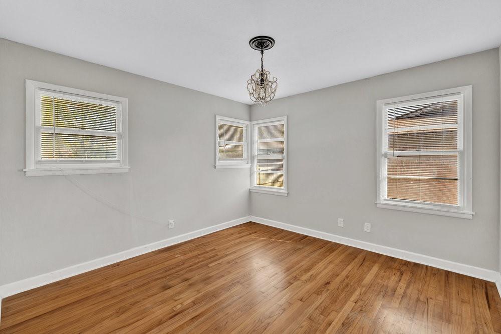 6833 Norma Street Fort Worth, TX 76112 - Photo 12 of 17 a view of an empty room with wooden floor and a window