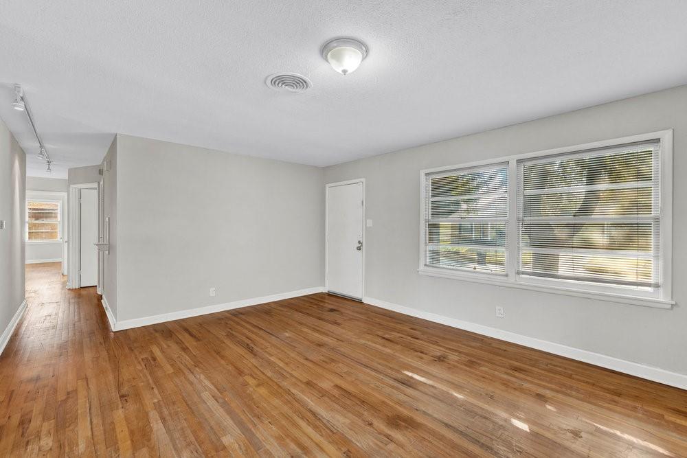 6833 Norma Street Fort Worth, TX 76112 - Photo 2 of 17 a view of an empty room with wooden floor and a window