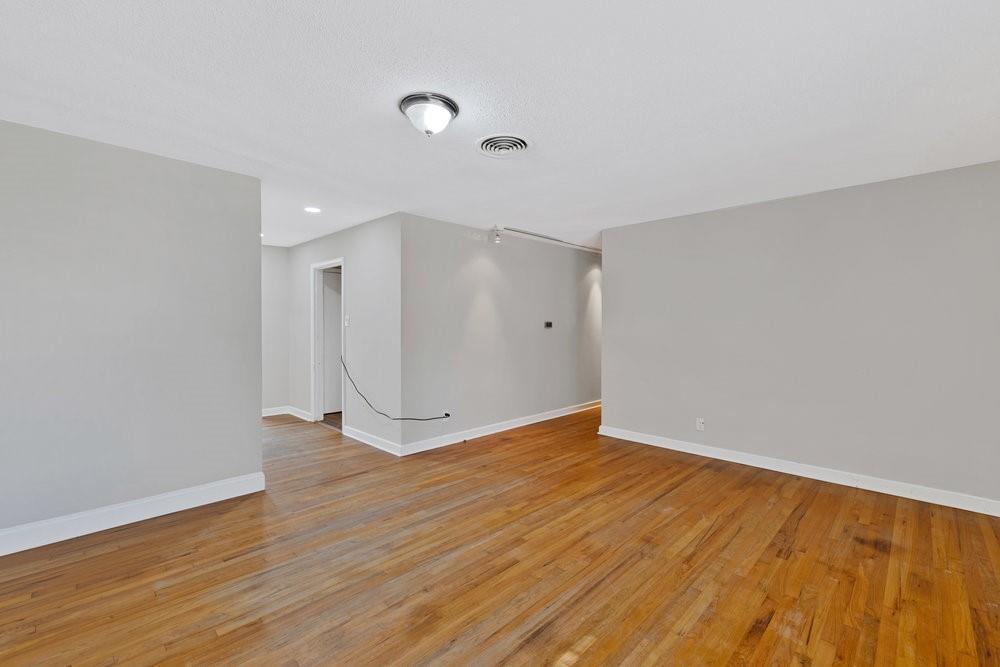 6833 Norma Street Fort Worth, TX 76112 - Photo 3 of 17 a view of an empty room with wooden floor