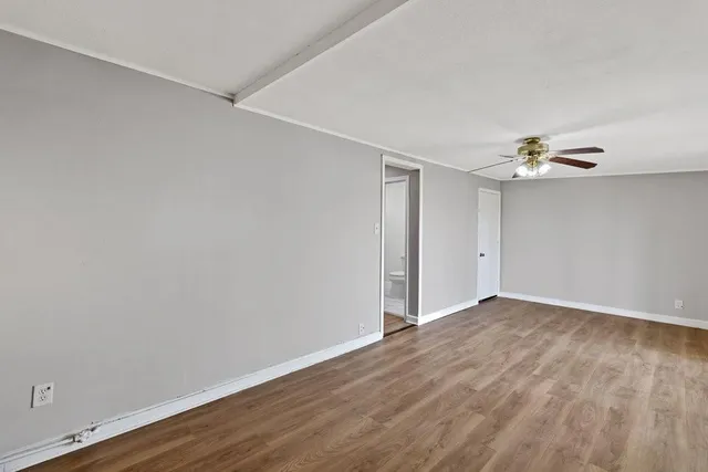 a view of an empty room with wooden floor