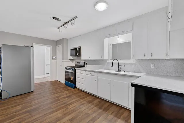 a large kitchen with stainless steel appliances and a refrigerator