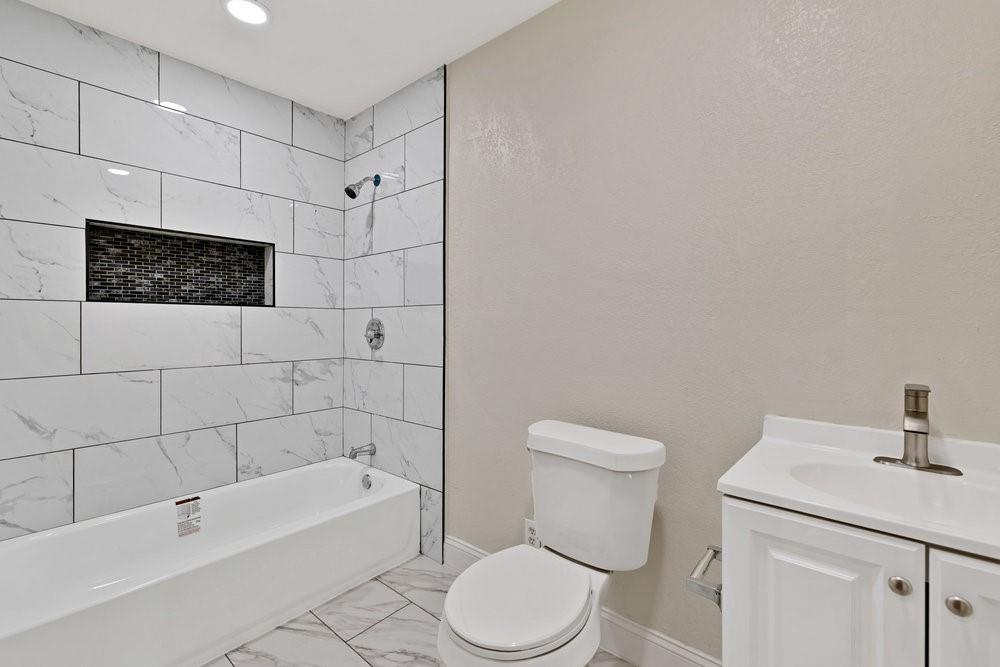 6833 Norma Street Fort Worth, TX 76112 - Photo 9 of 17 a bathroom with a toilet a sink and bathtub