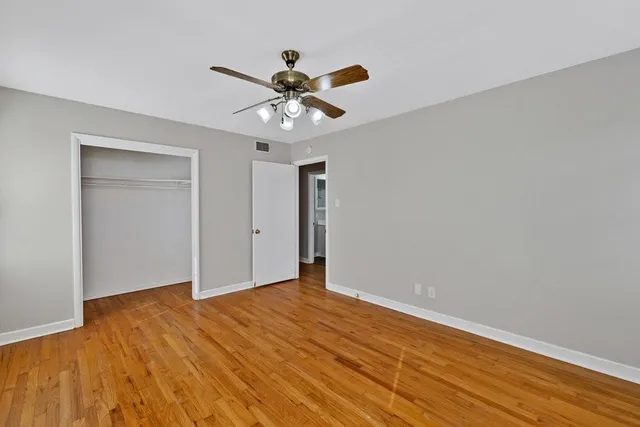a view of a room with window a ceiling fan and wooden floor