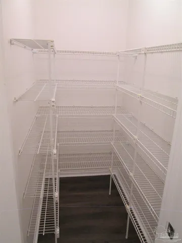 an empty room with wooden floor fireplace and windows