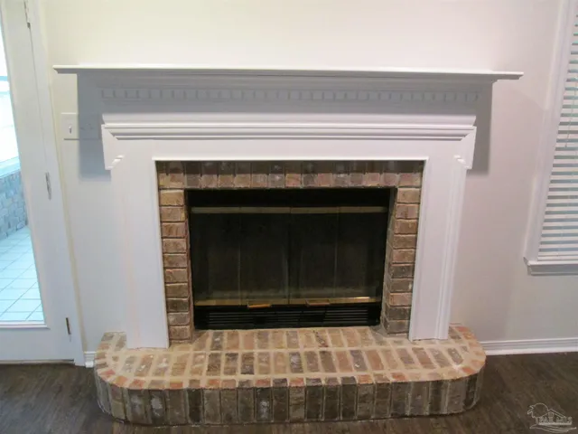 an empty room with wooden floor chandelier fan and windows