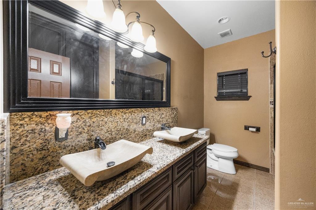 6813 North Gwin Road Edinburg, TX 78542 - Photo 16 of 20 a bathroom with a toilet sink and mirror