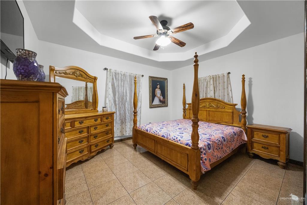 6813 North Gwin Road Edinburg, TX 78542 - Photo 17 of 20 a bedroom with a bed and a chandelier