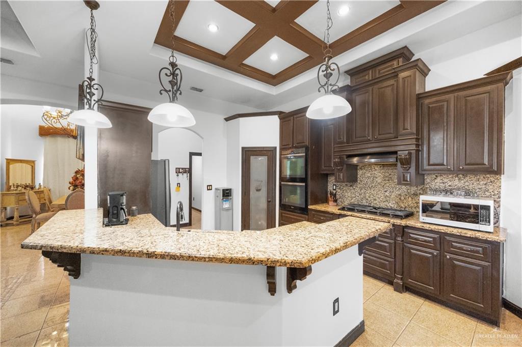 6813 North Gwin Road Edinburg, TX 78542 - Photo 8 of 20 a kitchen with kitchen island granite countertop a sink and refrigerator