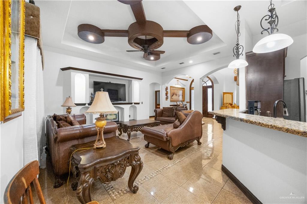 6813 North Gwin Road Edinburg, TX 78542 - Photo 10 of 20 a living room with furniture a chandelier fan and a large window