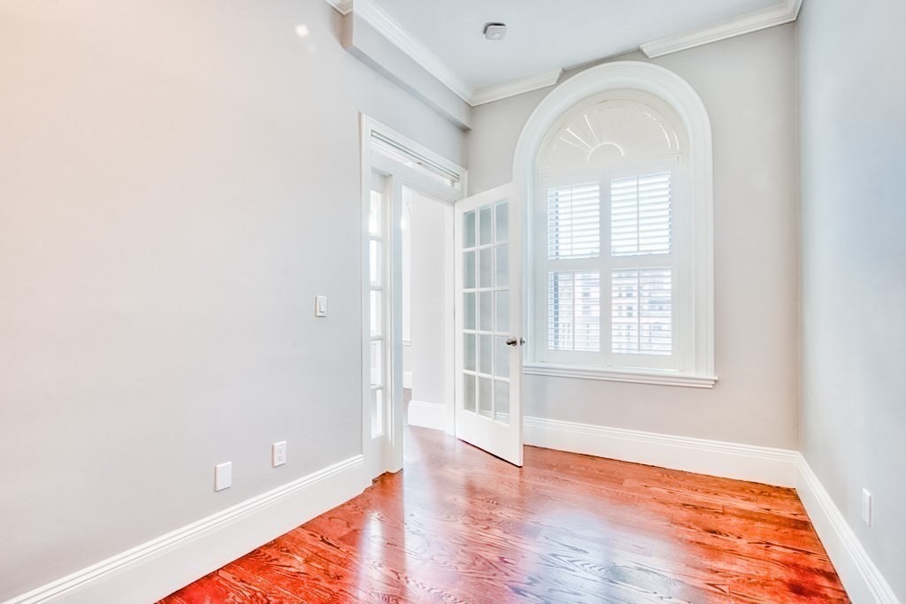 296 Commonwealth Avenue, Unit 5 Boston, MA 02115 - Photo 23 of 29 an empty room with wooden floor and windows