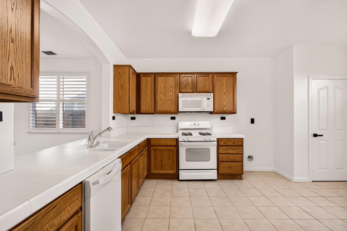 1825 Vermont Street Gridley, CA 95948 - Photo 18 of 57 a kitchen with granite countertop a sink stove and cabinets