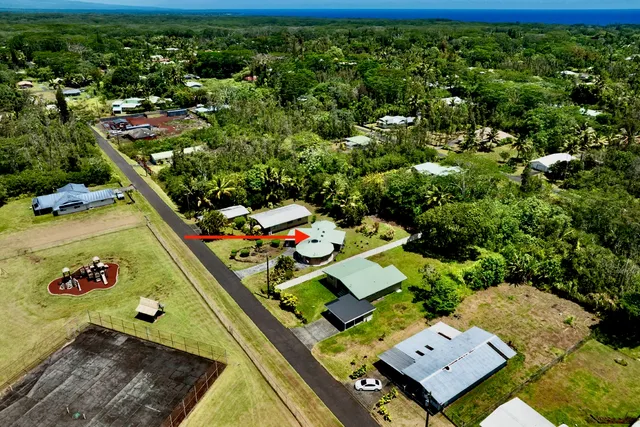 an aerial view of a residential houses with yard