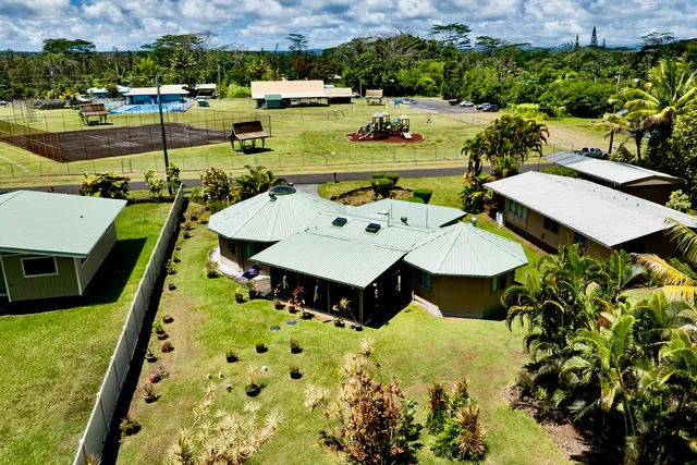 an aerial view of a house with swimming pool and ocean view