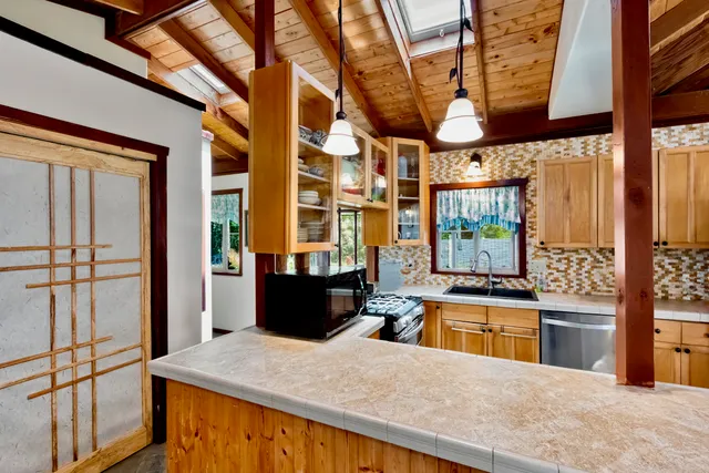 a kitchen with stainless steel appliances kitchen island granite countertop a sink and cabinets