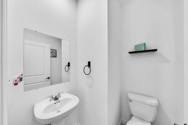 a bathroom with a sink a toilet and mirror