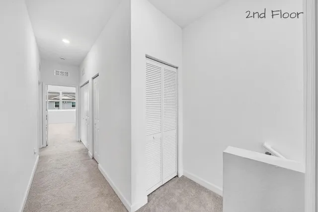 a view of a hallway with closet and wooden floor