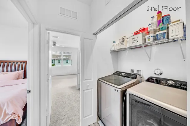 a utility room with dryer washer and shoe rack