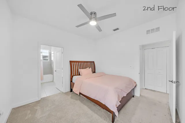 a bedroom with a bed and a ceiling fan