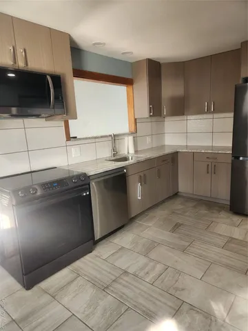 a kitchen with stainless steel appliances granite countertop a sink and a stove