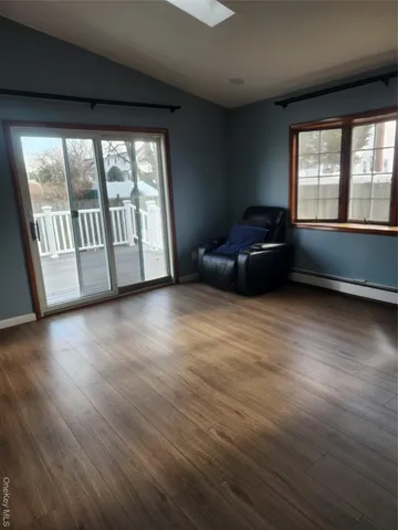 a living room with hardwood floor and a large window