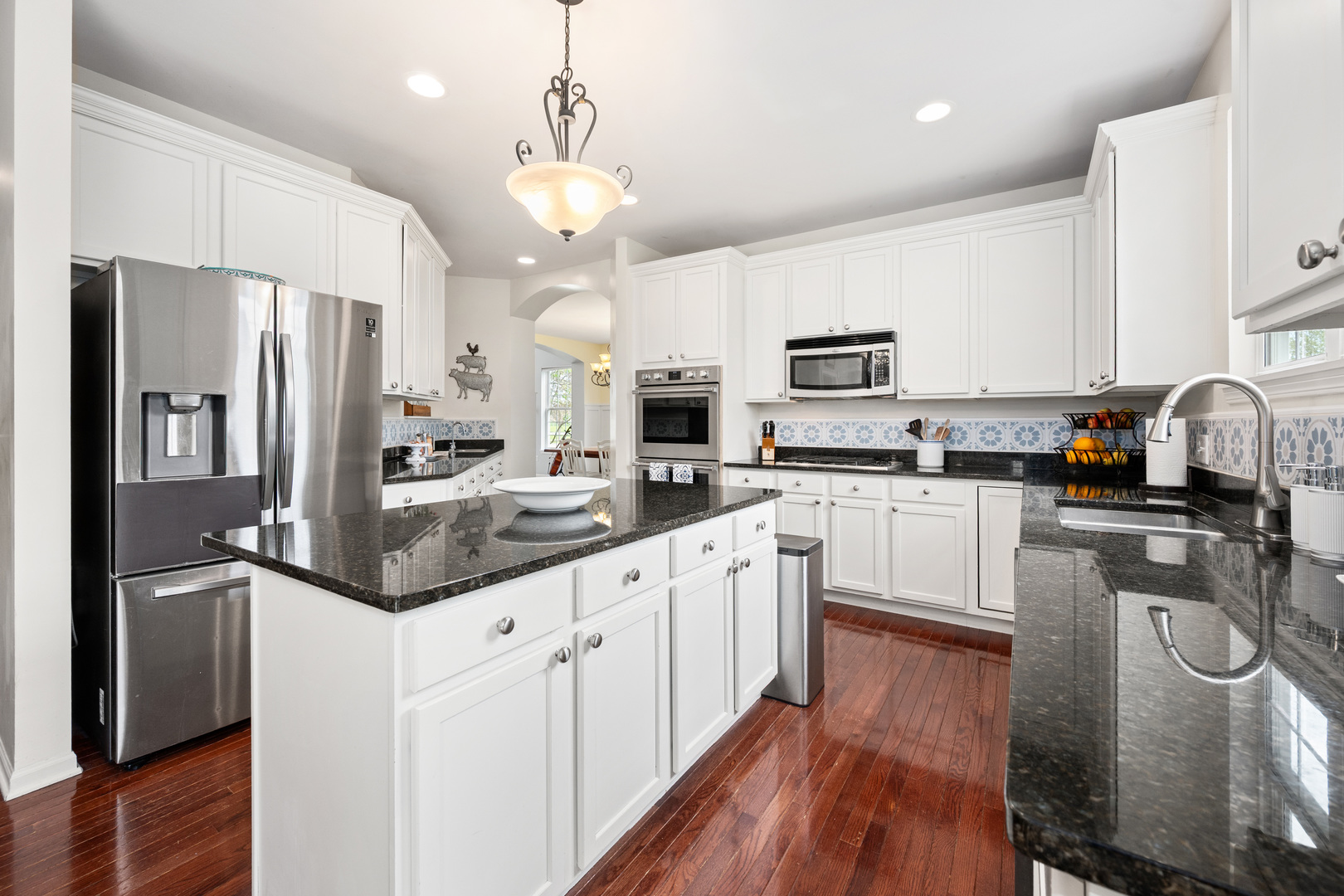 620 Northgate Drive Sycamore, IL 60178 - Photo 24 of 55 a kitchen with stainless steel appliances granite countertop a refrigerator a stove top oven a sink dishwasher and white cabinets with wooden floor