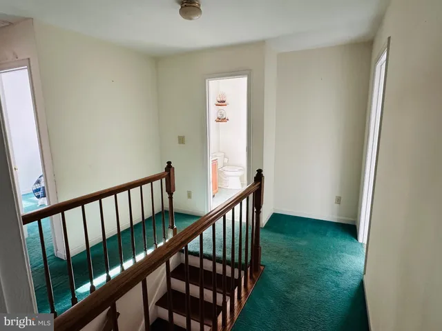 a view of staircase with railing and white walls