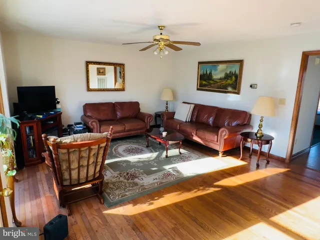 a living room with furniture a flat screen tv and a rug