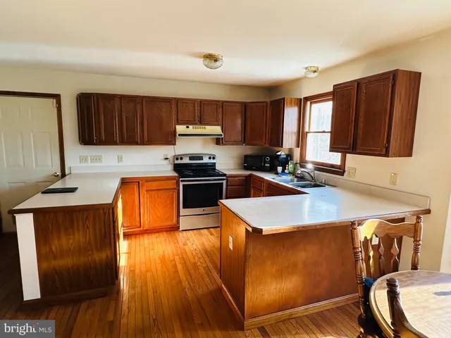 a kitchen with stainless steel appliances wooden cabinets sink and stove