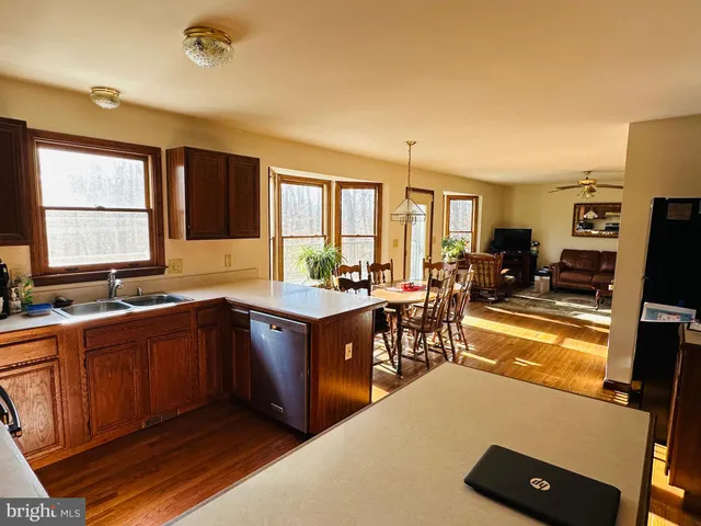 a large kitchen with kitchen island granite countertop a large window and stainless steel appliances