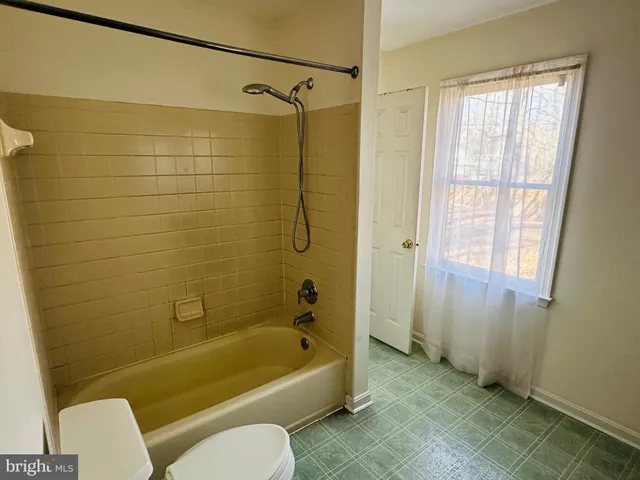 a bathroom with a tub shower and a sink