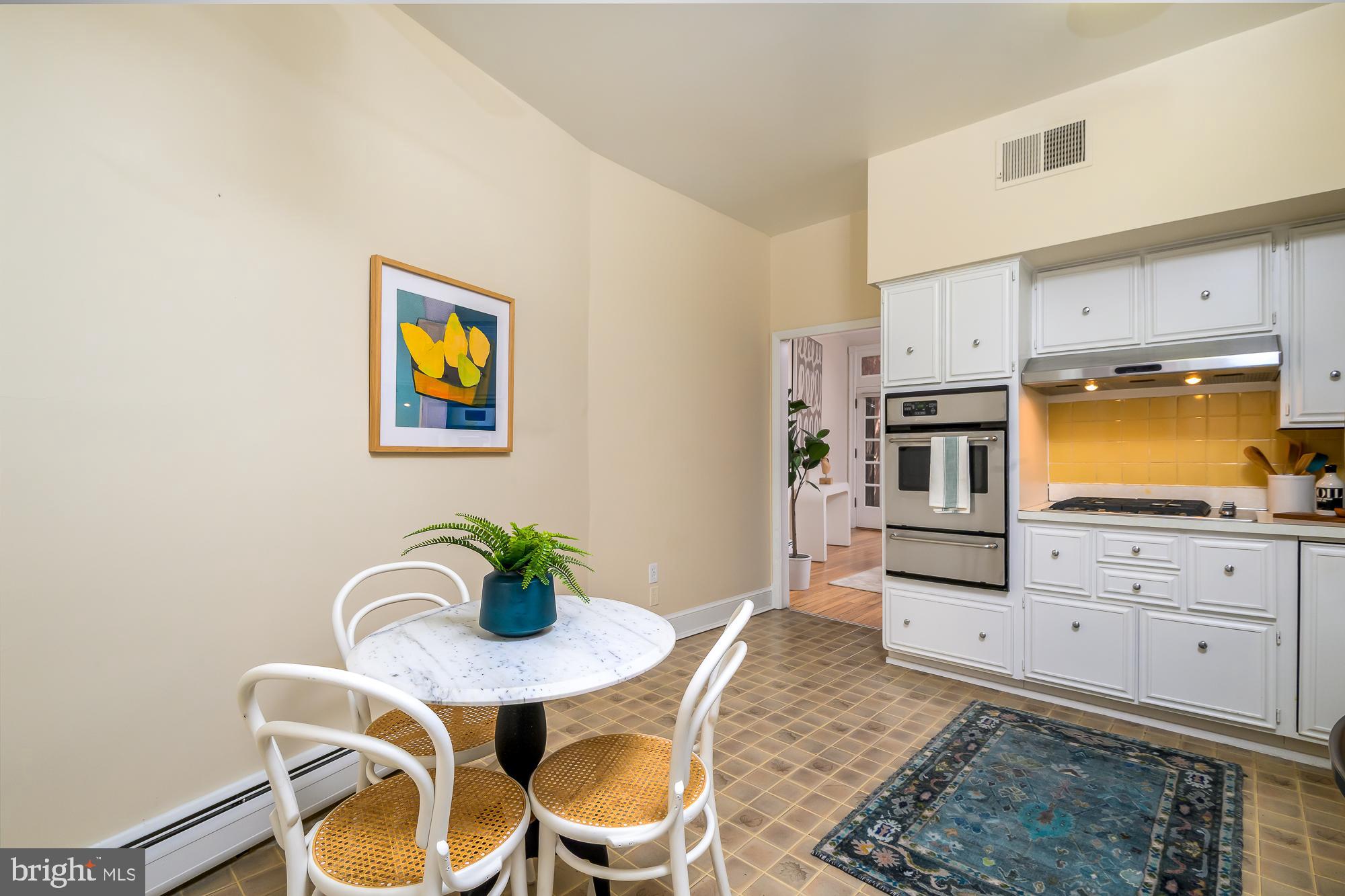 1330 Massachusetts Avenue Southeast Washington, DC 20003 - Photo 9 of 34 a kitchen with stainless steel appliances kitchen island granite countertop a sink a stove a dining table and chairs with wooden floor