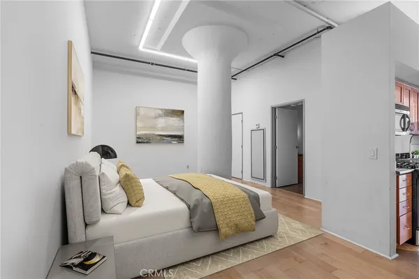 a bedroom with a bed and a painting on the wall