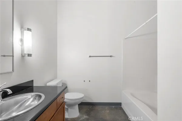 a bathroom with a granite countertop sink a toilet and shower
