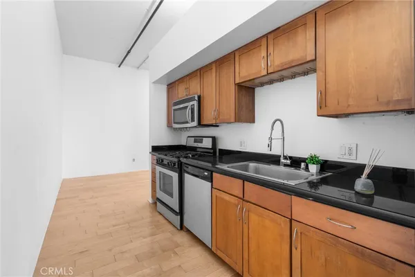 a kitchen with granite countertop a sink a stove and cabinets