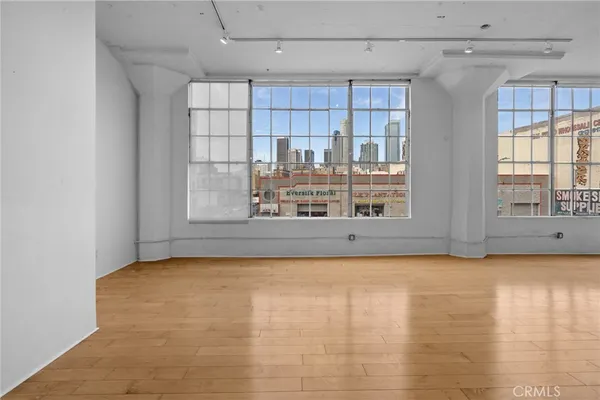 a view of an empty room with window and cabinet