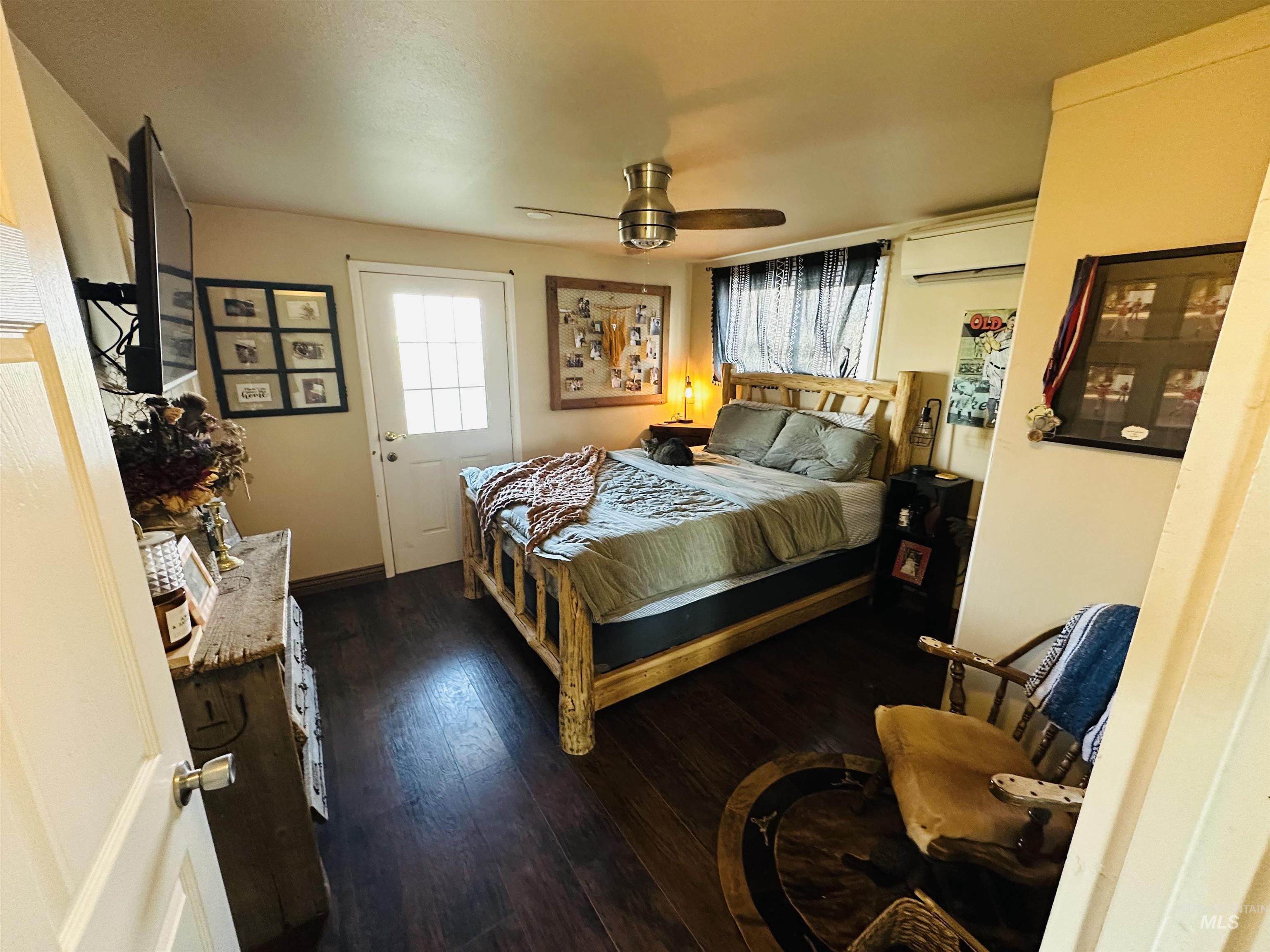 260 Highway 95 Weiser, ID 83672 - Photo 11 of 31 Bedroom featuring multiple windows, ceiling fan, dark wood-type flooring, and an AC wall unit